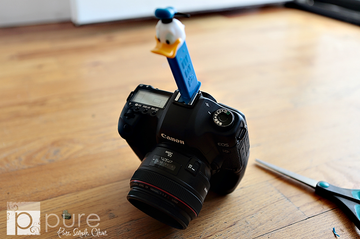 A camera with a Pez dispenser fitted into the hot shoe to help focus families' attention for portraits.