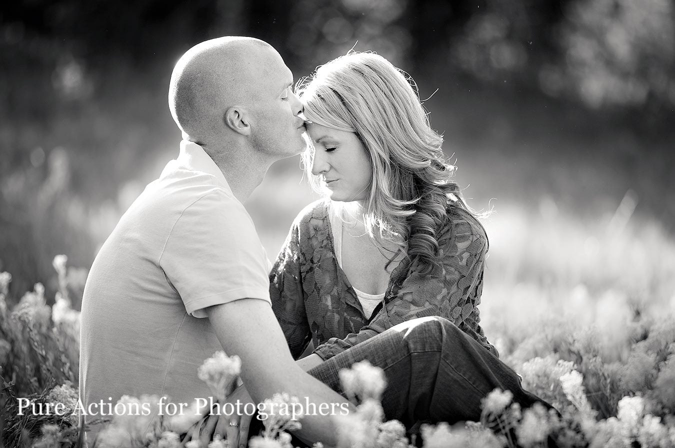An image of a couple kissing in a field of wild flowers in black and white edited with Pure Essential Edit Photoshop Actions and Lightroom Presets.