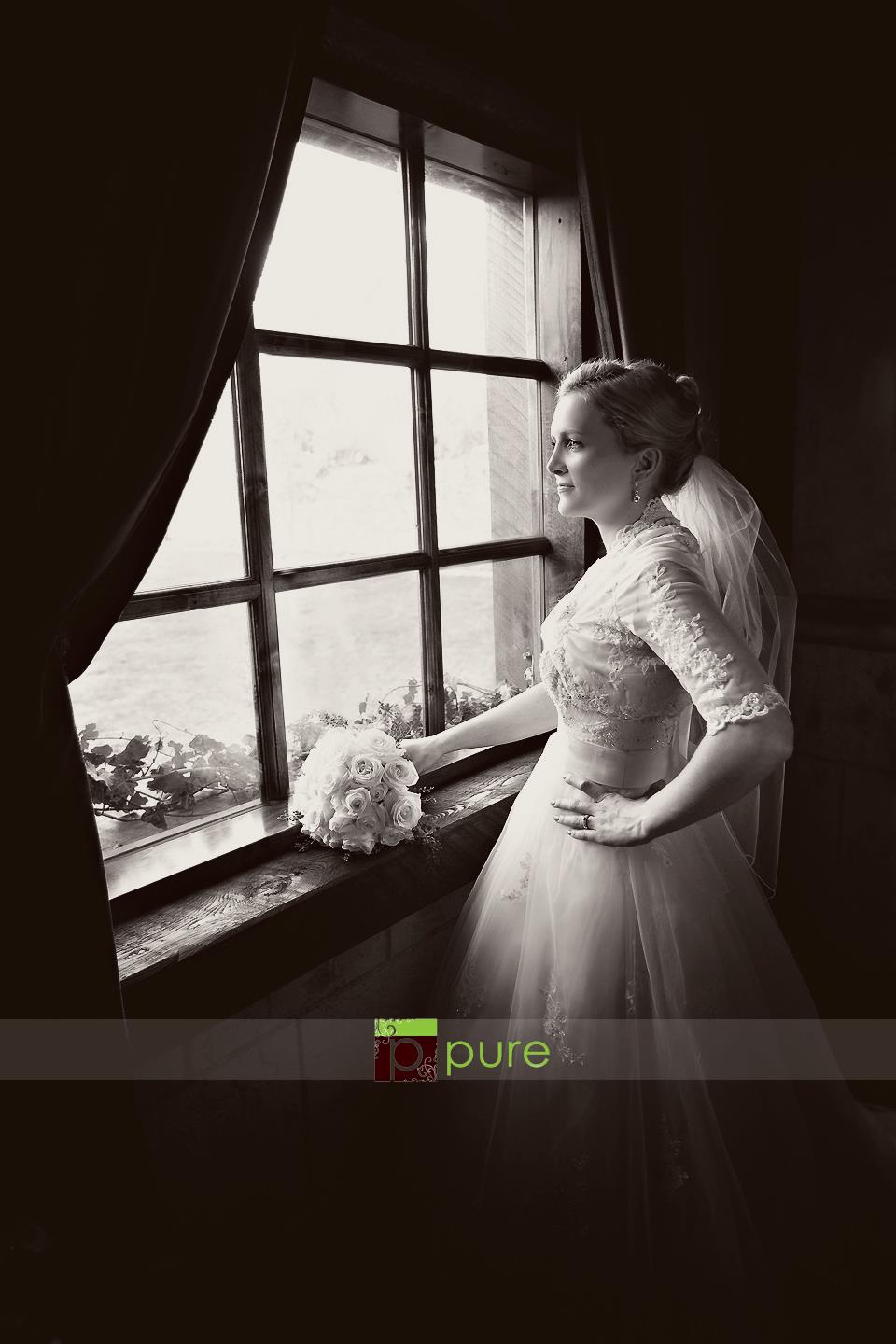 Photo of a bride in front of an old fashioned window with a lovely matted black and white old fashioned edit using Pure Split Tones Photoshop Actions.
