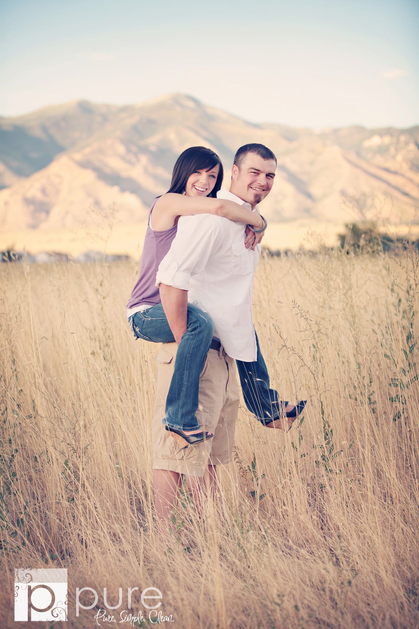 A Vintage toned image of a couple in a dreamy mountain and fieldl location edited using Purely Vintage Photoshop Actions.