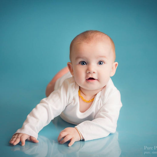 A photo of a baby on a seamless blue background demonstrating the Pure Retouch Photoshop technique using Photoshop Actions and Instructional videos.  The skin is very smooth and the tone is even and the blue background has no wrinkles or seams.