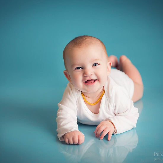 A photo of a baby on a seamless blue background demonstrating the Pure Retouch Photoshop technique using Photoshop Actions and Instructional videos.  The skin is very smooth and the tone is even and the blue background has no wrinkles or seams.