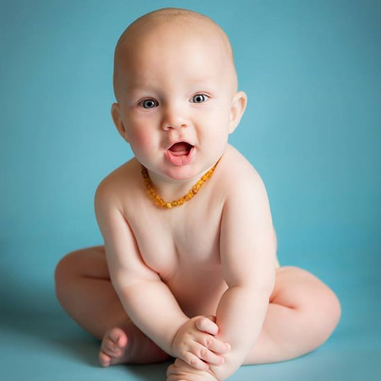A photo of a baby on a seamless blue background demonstrating the Pure Retouch Photoshop technique using Photoshop Actions and Instructional videos.  The skin is very smooth and the tone is even and the blue background has no wrinkles or seams.
