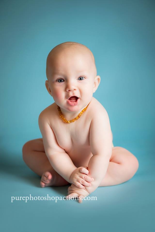 A photo of a baby on a seamless blue background demonstrating the Pure Retouch Photoshop technique using Photoshop Actions and Instructional videos.  The skin is very smooth and the tone is even and the blue background has no wrinkles or seams.