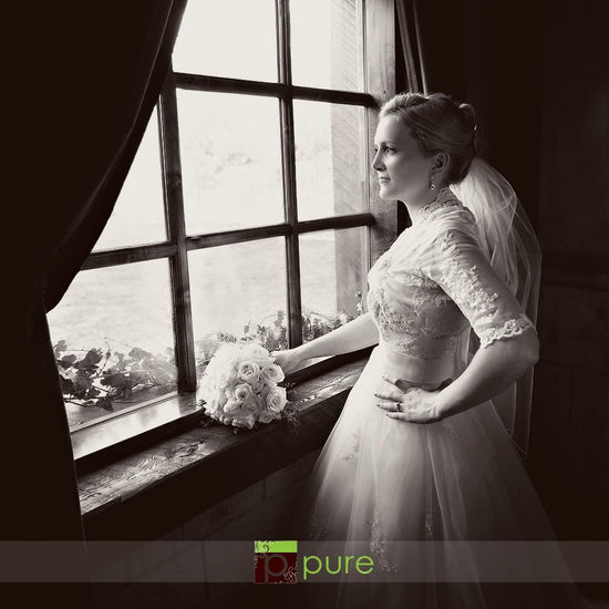 Photo of a bride in front of an old fashioned window with a lovely matted black and white old fashioned edit using Pure Split Tones Photoshop Actions.