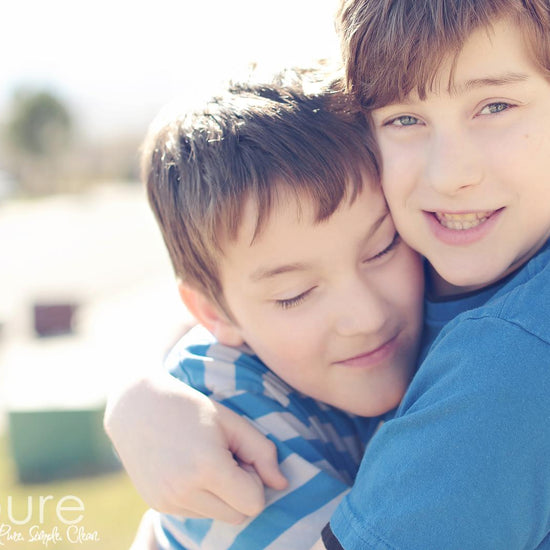Two brothers hugging with a vintage tone to the image demonstrating the effects of the Purely Vintage Photoshop Action set.