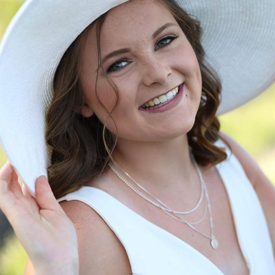 A before image of a woman in a large white hat and dress.
