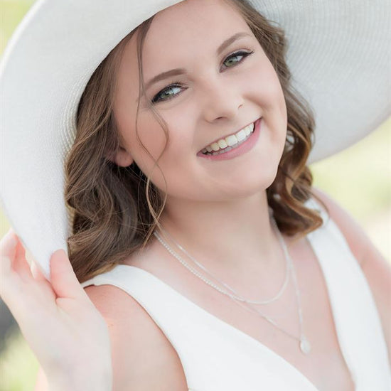 An after image of a woman in a large white hat and dress showcasing the effects of the Pure Soft and Airy Lightroom Presets set.