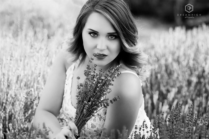 A black and white image of a young woman sitting in a lavender field edited with Pure Soft and Airy Photoshop Actions and Lightroom Presets.
